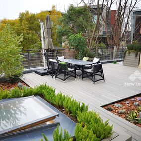 A product photo for NewTechWood composite decking, showing a nice outdoor deck with patio furniture