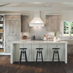 Waypoint kitchen image with island and stools. Cabinets are a rustic brown, while the island is white