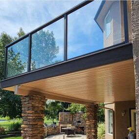 A photo showing an outdoor deck with a below patio being sheltered by the trex rain escape system