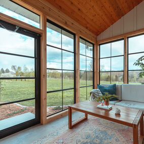 An image showing a beautiful outdoor sunroom with Porch Conversion featuring clear FlexiGlaze