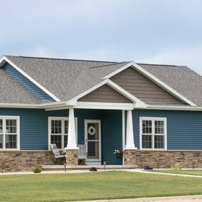 Image of homes exterior featuring blue siding and Versetta stone wainscoating