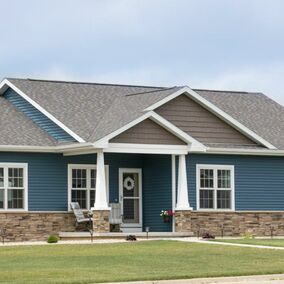 Home exterior featuring Versetta Stone Ledgestone veneer and blue siding